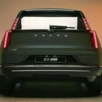 Volvo EX60 cinza visto de trás e com lanternas acesas